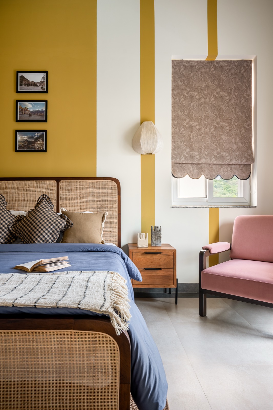 Blush pink armchair by the window in the mustard-banded bedroom