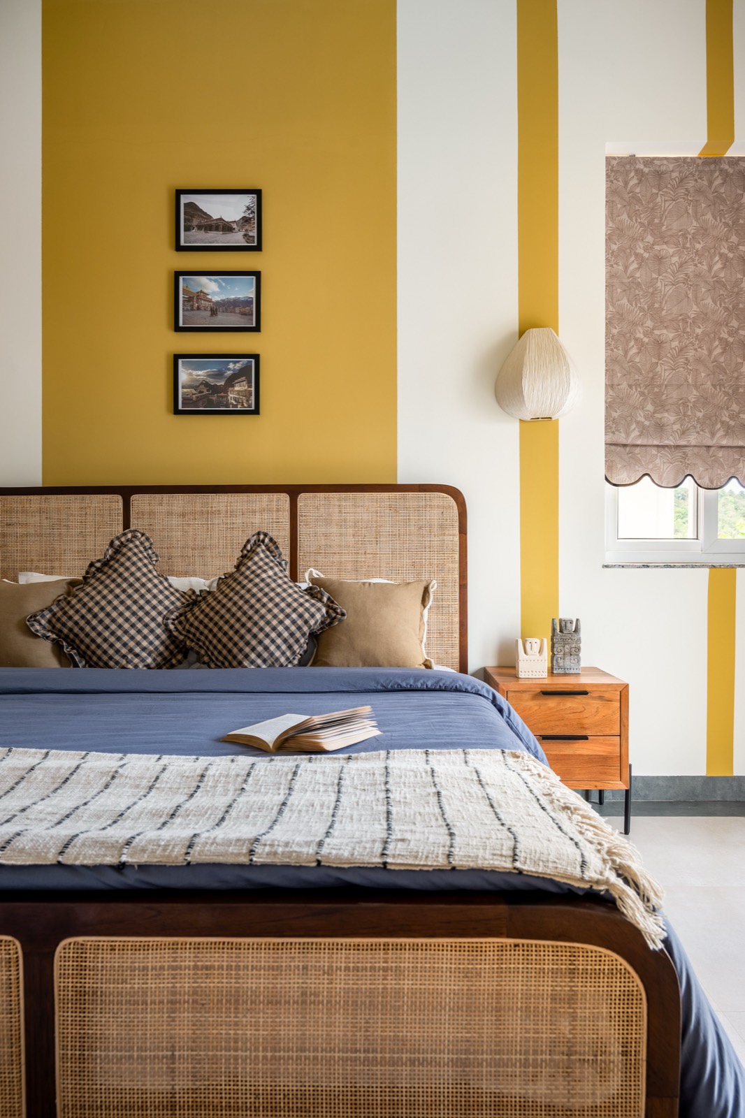 Cane bed dressed in denim blue and check cushions against mustard bands