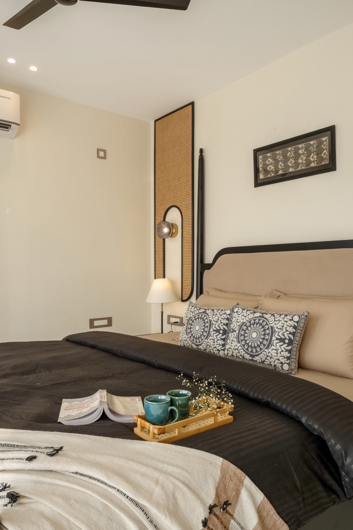 Charcoal bedding and block-printed cushions on the black four-poster bed