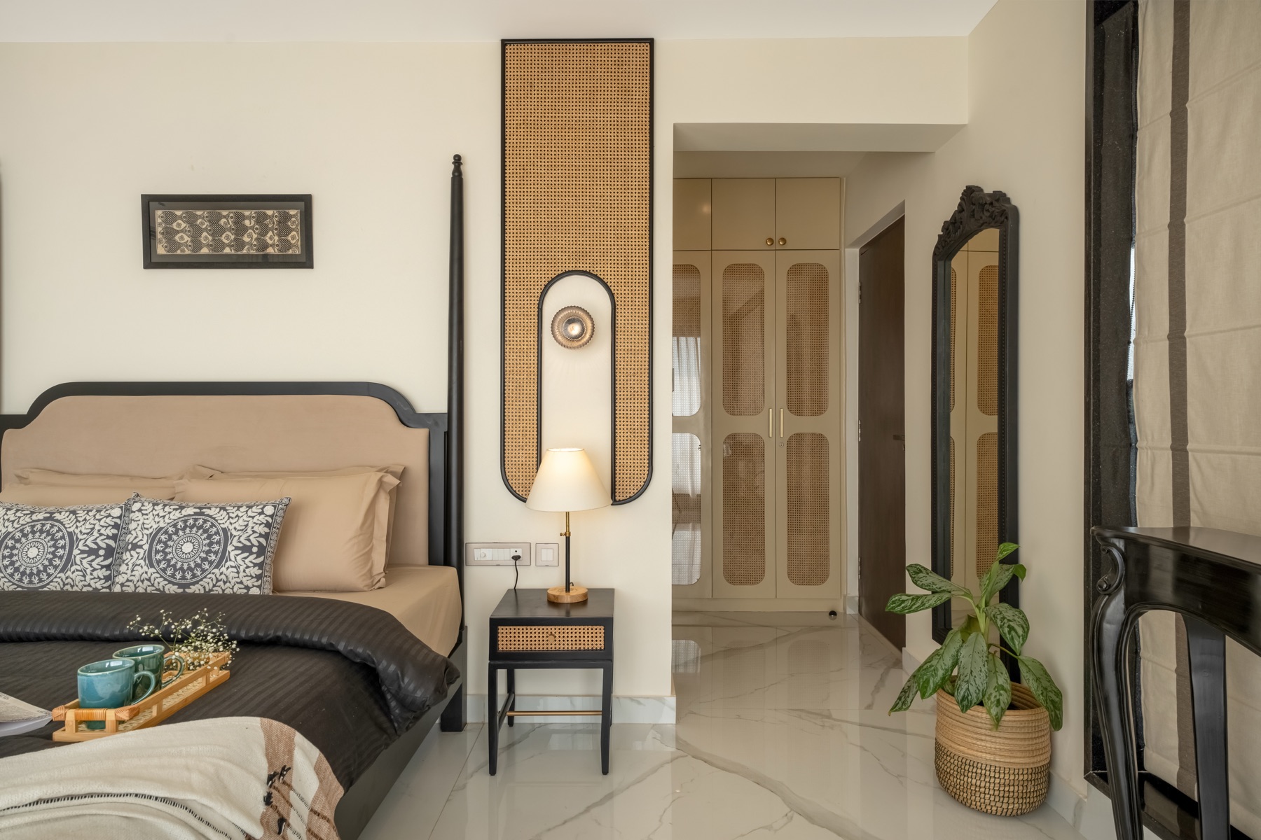 Four-poster bedroom with cane-fronted wardrobes and an arched cane wall panel