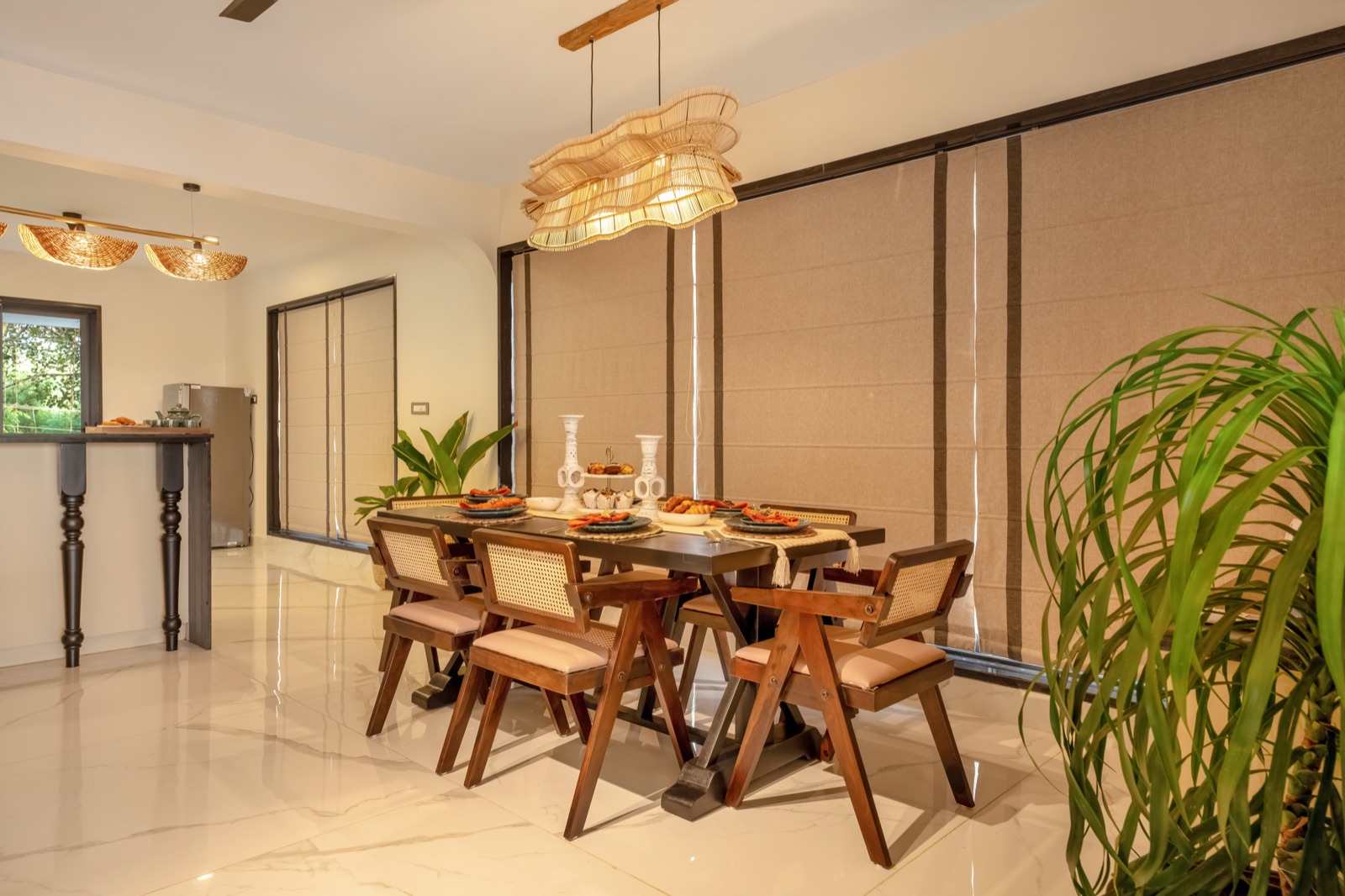 Dining corner with cane-backed chairs and woven pendant lights