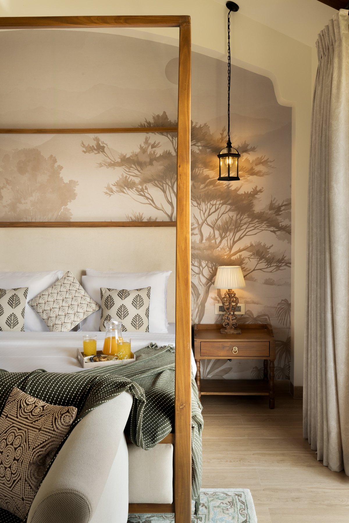 Timber four-poster and hanging lantern beside the painted mural wall