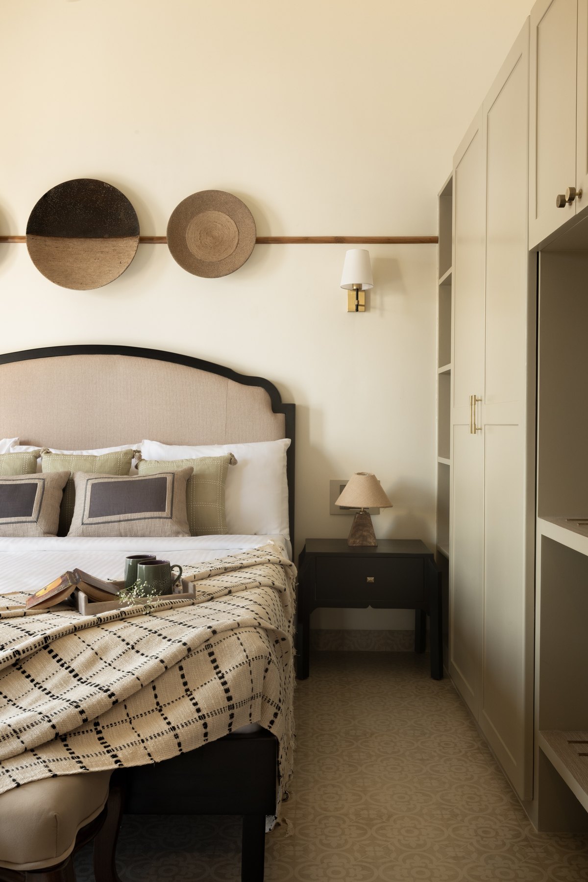 Arched upholstered headboard beside the fitted wardrobes