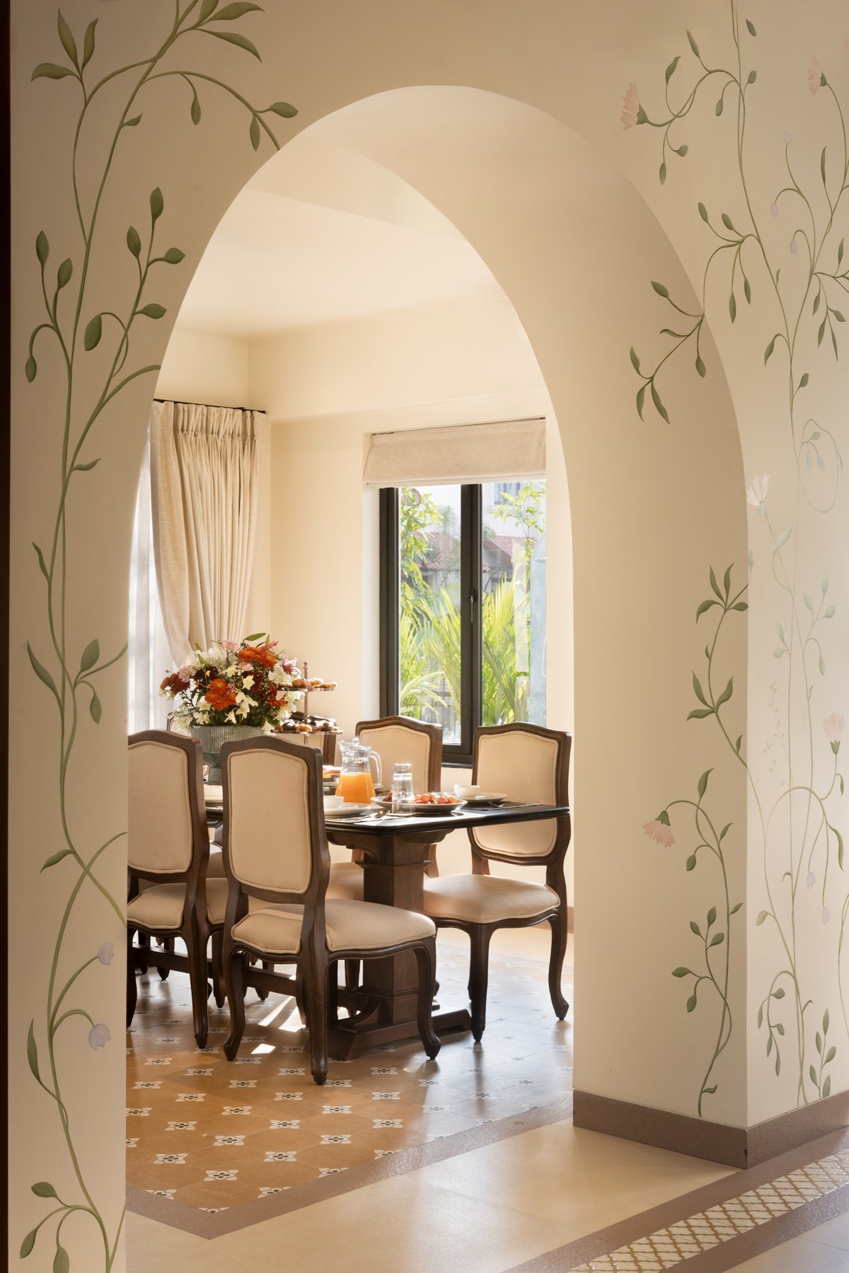 Vine-painted arch opening to the dining room and its garden window