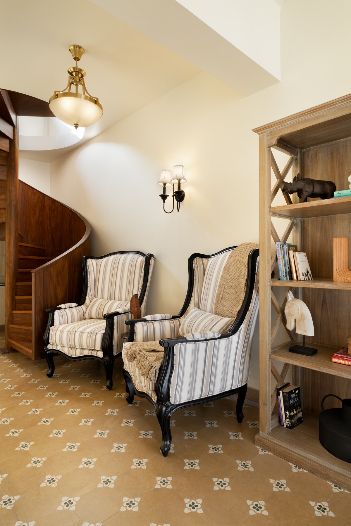 Striped wing chairs and open shelving on the patterned tile landing