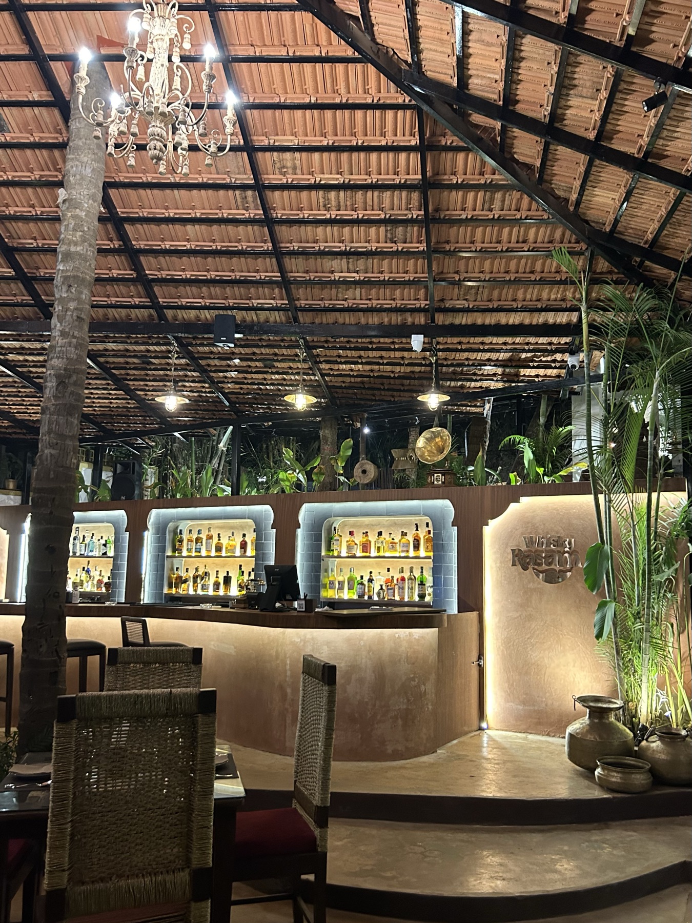 Chandeliers hung from the tiled roof above the glowing arched backbar