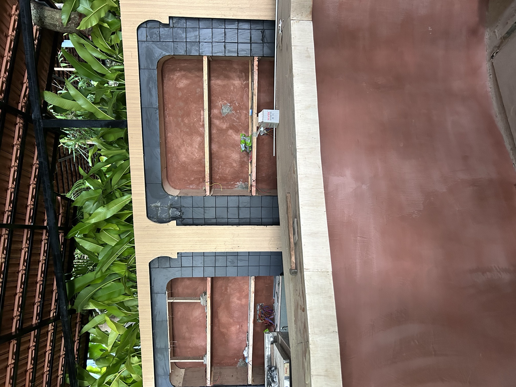 The bar shell in raw plaster during the twenty-day build, arched niches roughed out